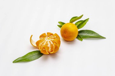 Yapraklarla dolu olgun mandalinalar. Beyaz arkaplanda izole edilmiş taze meyveler