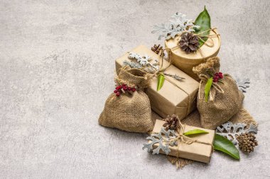Noel sıfır atık konsepti. Yeni yıl çevre dostu paketleme. Farklı organik süslemeleri olan el işi kağıt ve çuvallardaki kutular.