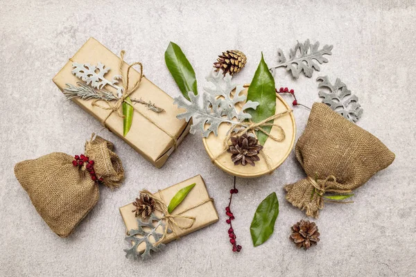 Noel sıfır atık konsepti. Yeni yıl çevre dostu paketleme. Farklı organik süslemeleri olan el işi kağıt ve çuvallardaki kutular. — Stok fotoğraf