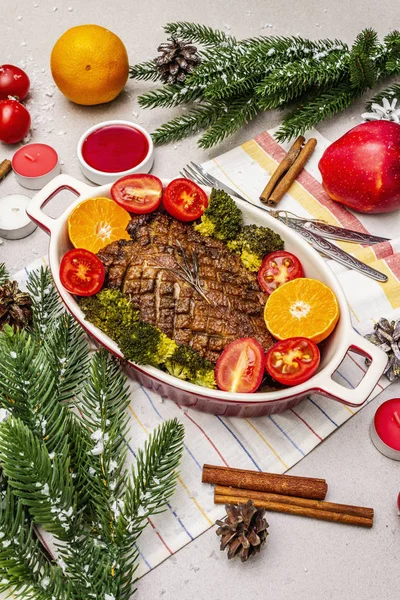 Печёная утиная грудка на кости с овощами и соусом. Рождественский ужин, сервировка новогоднего стола. Каменный бетон — стоковое фото