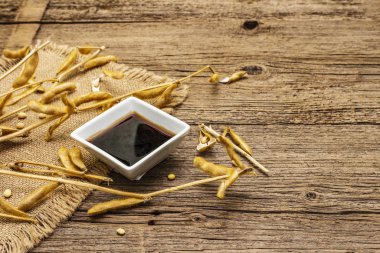 Kabuklu kuru fasulye ve soya sosu. Organik tarım mahsulleri, geleneksel sağlıklı doğu yiyecekleri. Klasik çuval bezi, tahta tahta arka plan