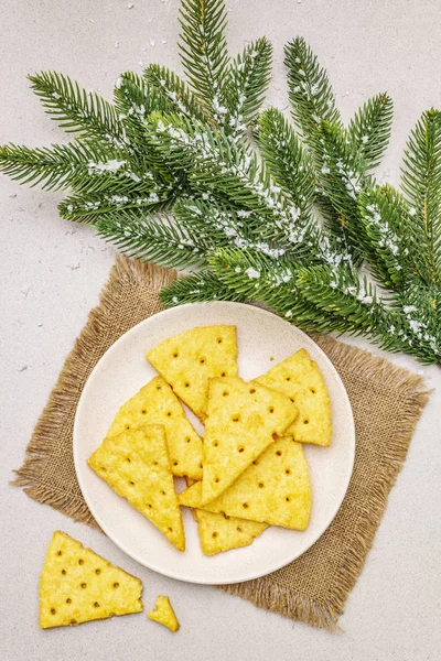 Γιορτινά κρακεράκια τυριού, πρωτοχρονιάτικο σνακ. Cookies, κλαδί ελάτης, τεχνητό χιόνι, χαρτοπετσέτα. Πέτρα φόντο τσιμέντο — Φωτογραφία Αρχείου