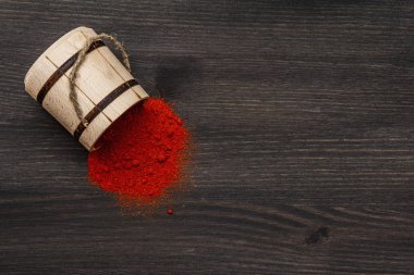Macar (Macar) parlak kırmızı paprika tozu. Ulusal yemek pişirmek için geleneksel baharat. Tahta fıçı, siyah ahşap arka plan