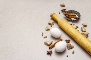 Noel yemeği geçmişi, baharatlar, yumurtalar, esmer şeker, kek pişirme kabı ve merdane. Hafif taş beton arkaplan