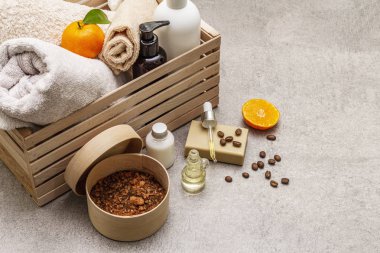 Kahve ve mandalina spa konsepti. Havlular, yağ, fırça, sabun, losyon. Doğal malzeme, ahşap kutu. Taş beton arka plan