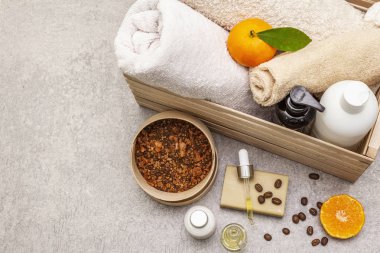 Kahve ve mandalina spa konsepti. Havlular, yağ, fırça, sabun, losyon. Doğal malzeme, ahşap kutu. Taş beton arka plan
