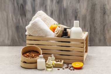 Kahve ve mandalina spa konsepti. Havlular, yağ, fırça, sabun, losyon. Doğal malzeme, ahşap kutu. Taş beton arka plan