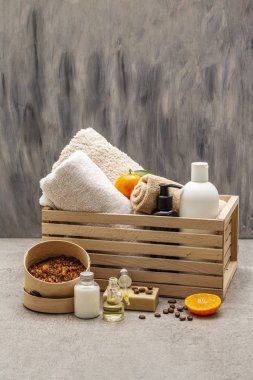 Kahve ve mandalina spa konsepti. Havlular, yağ, fırça, sabun, losyon. Doğal malzeme, ahşap kutu. Taş beton arka plan