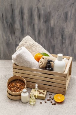 Kahve ve mandalina spa konsepti. Havlular, yağ, fırça, sabun, losyon. Doğal malzeme, ahşap kutu. Taş beton arka plan