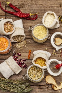 Sıfır yiyecek alışverişi konsepti. Mısır gevreği, makarna, baklagil, kurutulmuş mantar, baharat. Sürdürülebilir yaşam tarzı, eski tahta arka plan