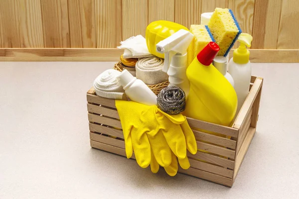 Producto de limpieza de casas en caja de madera. Spray, botella, guantes, esponja lavavajillas, rascador, ambientador de gel. Fondo de hormigón piedra —  Fotos de Stock
