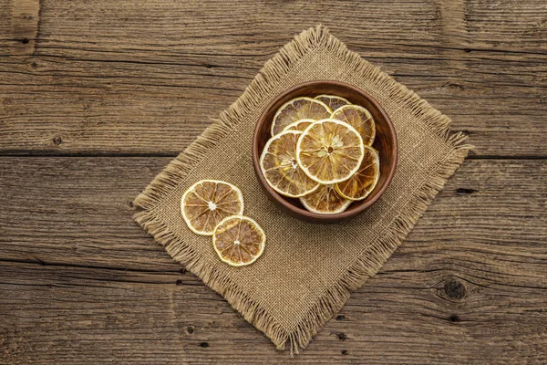 Сушеные ломтики лимона в миске. Фруктовые закуски, понятие здорового питания — стоковое фото