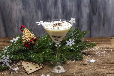 Traditional prune dessert with nuts and whipped sour cream with sugar. New Year's sweet treat concept. Wooden boards background