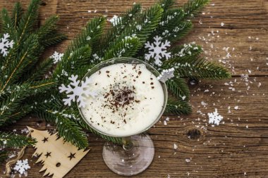 Traditional prune dessert with nuts and whipped sour cream with sugar. New Year's sweet treat concept. Wooden boards background