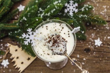 Traditional prune dessert with walnuts and whipped sour cream with sugar. New Year's sweet treat concept. Wooden boards background, selective focus
