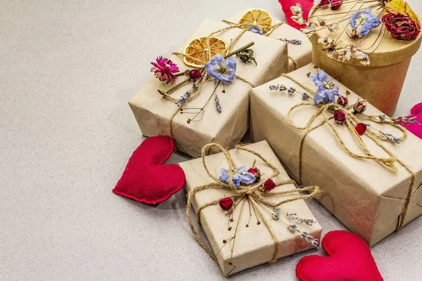Zero waste gift concept. Valentine Day or Birthday eco friendly packaging. Festive boxes in craft paper with different organic decorations. Stone concrete background — Stockfoto