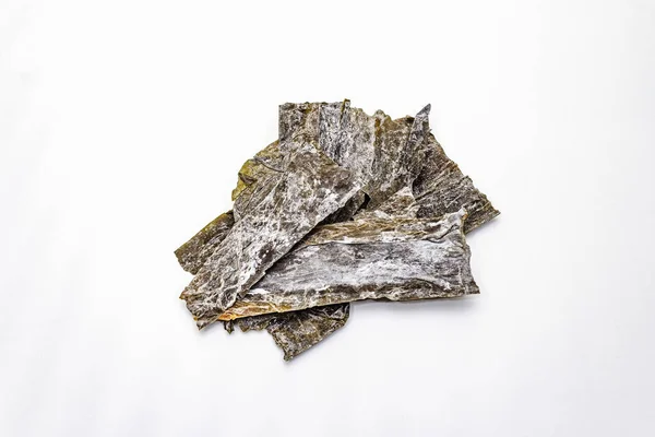 Dry laminaria japonica kelp isolated on white background. Kombu seaweed, traditional Japanese ingredient for cooking Dashi soup — 스톡 사진