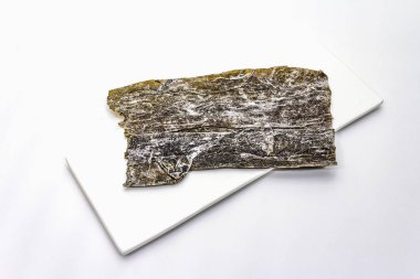 Kuru laminaria japonica yosunu beyaz arka planda izole edilmiş. Kombu yosunu, Dashi çorbası pişirmek için geleneksel Japon malzemesi.