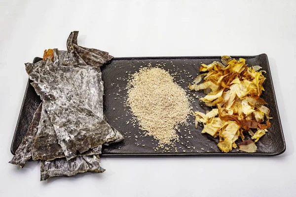 Set of traditional Japanese ingredient for cooking basic dashi broth. Algae kombu, katsuobushi and finished dry granules. Isolated on white background — Stock Photo, Image