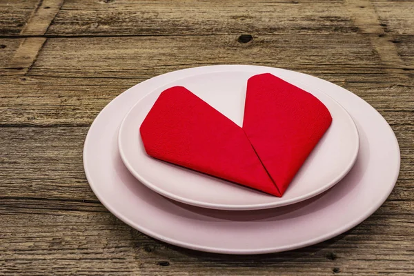 Romantyczny stół z talerzami i serwetką w kształcie serca. Koncepcja miłości na Walentynki lub Dzień Matki, sztućce ślubne. Vintage drewniane deski tła — Zdjęcie stockowe