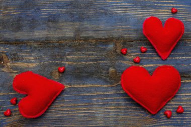 Sevgililer günü ya da anneler günü için aşk konsepti. Metin için boşluğu olan kart. Kırmızı keçeli kalpler, boncuklar, eski tahta arka plan