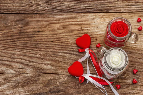 Kjærlighetskonseptet for Valentines dag eller mødredag. Rødt filthjerte, glasskrukke, roser, bånd. Gamle treplanker – stockfoto