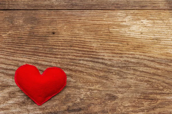 Liefdesconcept voor Valentijnsdag of moederdag. Kaart met ruimte voor tekst. Rood vilten hart, oude houten planken achtergrond — Stockfoto