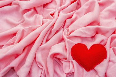 Sevgililer Günü ya da düğün kartı konsepti. Romantik tasarım, kırmızı keçeli kalp. Pembe kumaş arkaplanı