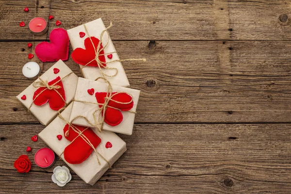 Concetto regalo zero rifiuti. Imballaggio ecologico San Valentino o Wedding. Scatole festive in carta artigianale con cuori di feltro rosso. Vintage sfondo in legno — Foto Stock