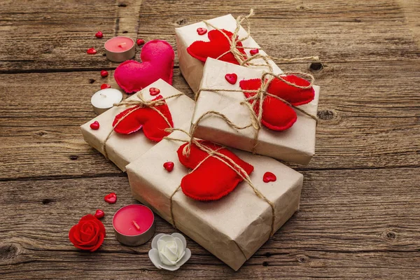 Zero waste gift concept. Valentine Day or Wedding eco friendly packaging. Festive boxes in craft paper with red felt hearts. Vintage wooden background — 스톡 사진