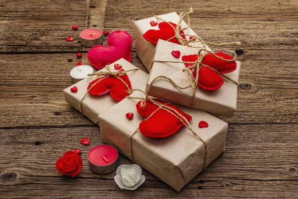 Zero waste gift concept. Valentine Day or Wedding eco friendly packaging. Festive boxes in craft paper with red felt hearts. Vintage wooden background — 스톡 사진