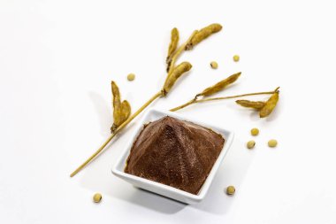 Açık kahverengi miso macunu beyaz arkaplanda izole edilmiş. Geleneksel Japon baharatı, kuru soya fasulyesi kabukları.