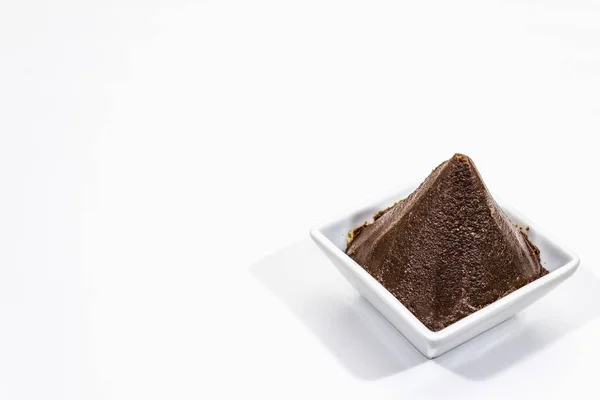 Pasta de miso marrón oscuro aislada sobre fondo blanco. Sazón tradicional japonés, ingrediente indispensable para cocinar caldo de sopa — Foto de Stock