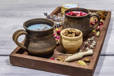 İki aşık için romantik renkli kahve seti. Lavanta ve gül, pudra aromalı şeker, baharatlar. Sevgililer Günü konsepti. Tepsi, tahta tahta arka plan