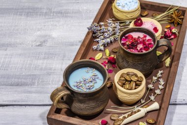 İki aşık için romantik renkli kahve seti. Lavanta ve gül, pudra aromalı şeker, baharatlar. Sevgililer Günü konsepti. Tepsi, tahta tahta arka plan