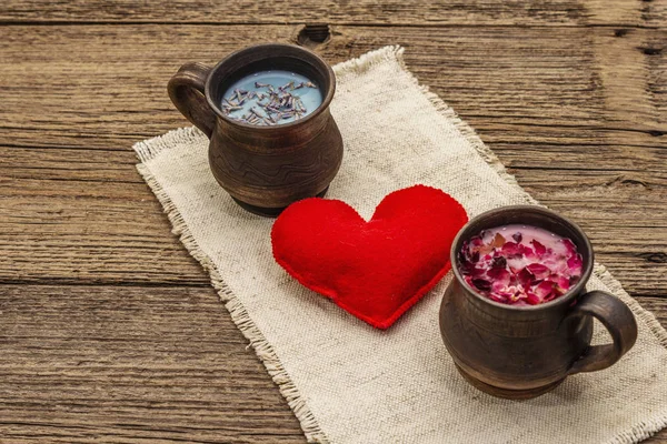 Moon Milk for a better sleep. Rose petals and lavender, felt heart. Valentines Day, romantic concept. Trendy relaxing bedtime drink. Old wooden background