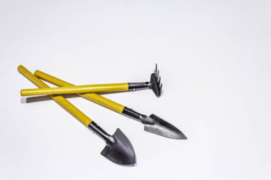Beyaz arka planda izole edilmiş bahçe araçları. Bitki bakımı konsepti. Kürek ve tırmık.