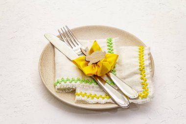 Beyaz macun arkaplanda paskalya masası ayarı. Bahar tatili kartı şablonu. Çatal bıçak, eski peçete, tavşan, çiçek.