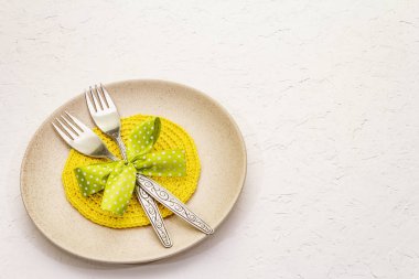 Beyaz macun arkaplanda paskalya masası ayarı. Bahar tatili kartı şablonu. Çatal bıçak takımı, örgü peçete, bağlı fiyonk.