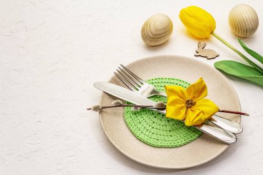 Beyaz macun arkaplanda paskalya masası ayarı. Bahar tatili kartı şablonu. Çatal bıçak, peçete, yumurta, tavşan, lale.