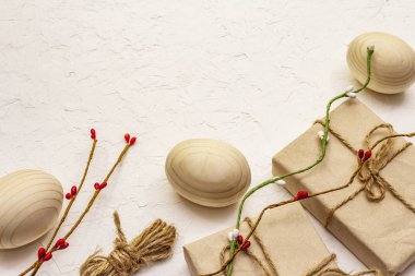 Zero waste Easter concept. Wooden eggs, gifts in craft paper. Not plastic, eco trend. White putty background