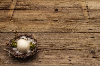 Paskalya kuşu yuvası. Sıfır israf, DIY konsepti. Tahta yumurta, tüy, yosun. Eski tahta arkaplanı, kopyala