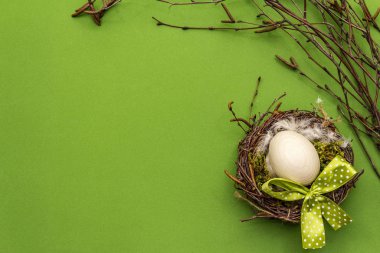 Paskalya sıfır atık dekoru, DIY konsepti. Tasarım elemanı ve dekor. Kuş yuvası, yumurta, yosun, huş ağacı dalları, tüy. Yeşil arkaplan, üst görünüm, kopyalama alanı