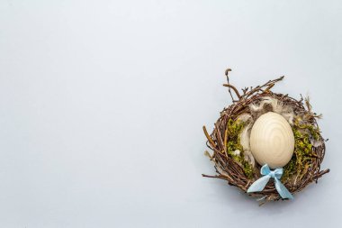 Paskalya kuşu yuvası. Sıfır israf, DIY konsepti. Yumuşak tüyler, yumurta, yosun. Açık mavi arkaplan, boşluk kopyala, üst görünüm