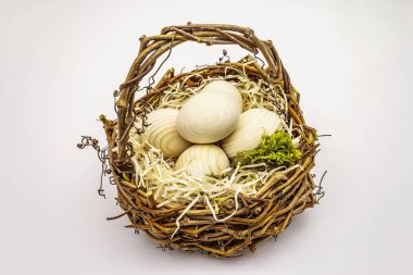 Paskalya hasır sepeti beyaz arka planda izole edilmiş. Sıfır israf, DIY konsepti. Tahta yumurta, talaş, yosun.