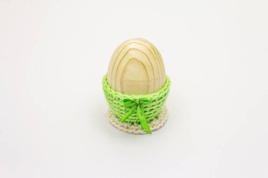 Yeşil örülmüş ahşap yumurta beyaz arka planda izole edilmiş duruyor. Paskalya sıfır atık kavramı
