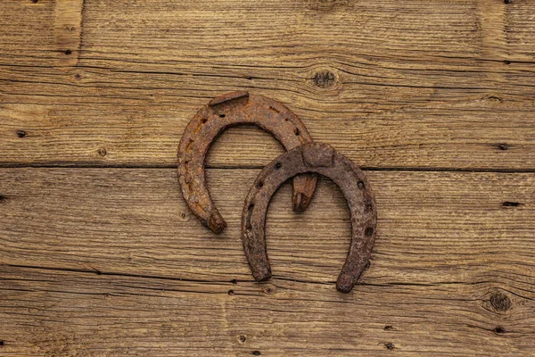 Cast iron metal horse horseshoes. Good luck symbol, St.Patrick\'s Day concept. Old wooden background, horse accessories, top view