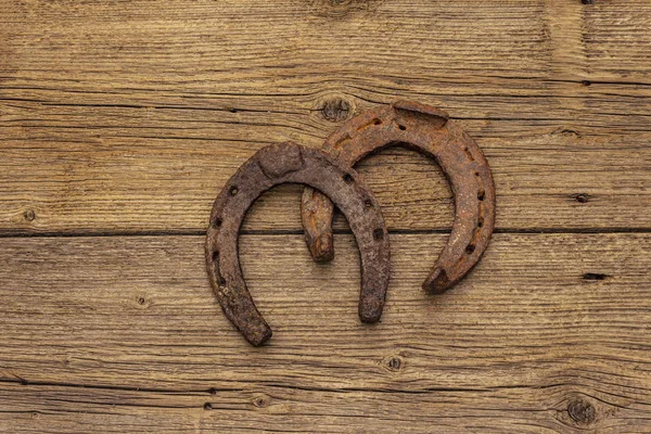 Cast iron metal horse horseshoes. Good luck symbol, St.Patrick\'s Day concept. Old wooden background, horse accessories, top view