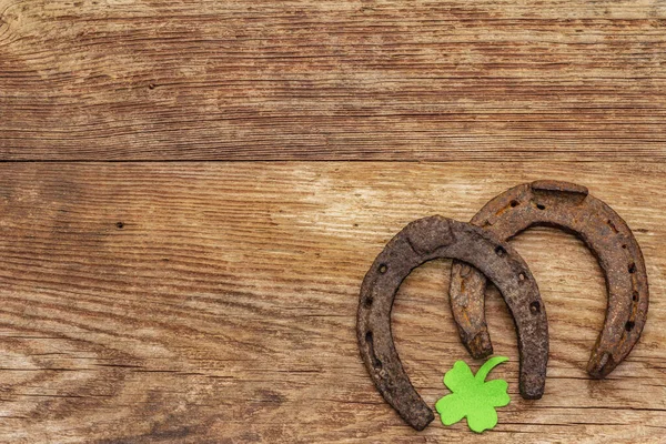 两只铸铁马蹄 感觉丁香叶 祝好运 圣帕特里克节的概念 旧木制背景 马匹配件 顶视图 — 图库照片