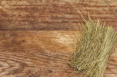 Eski ahşap arka planda saman yığını. Kuru otlar, evcil hayvanlar için yiyecekler, üst manzara.